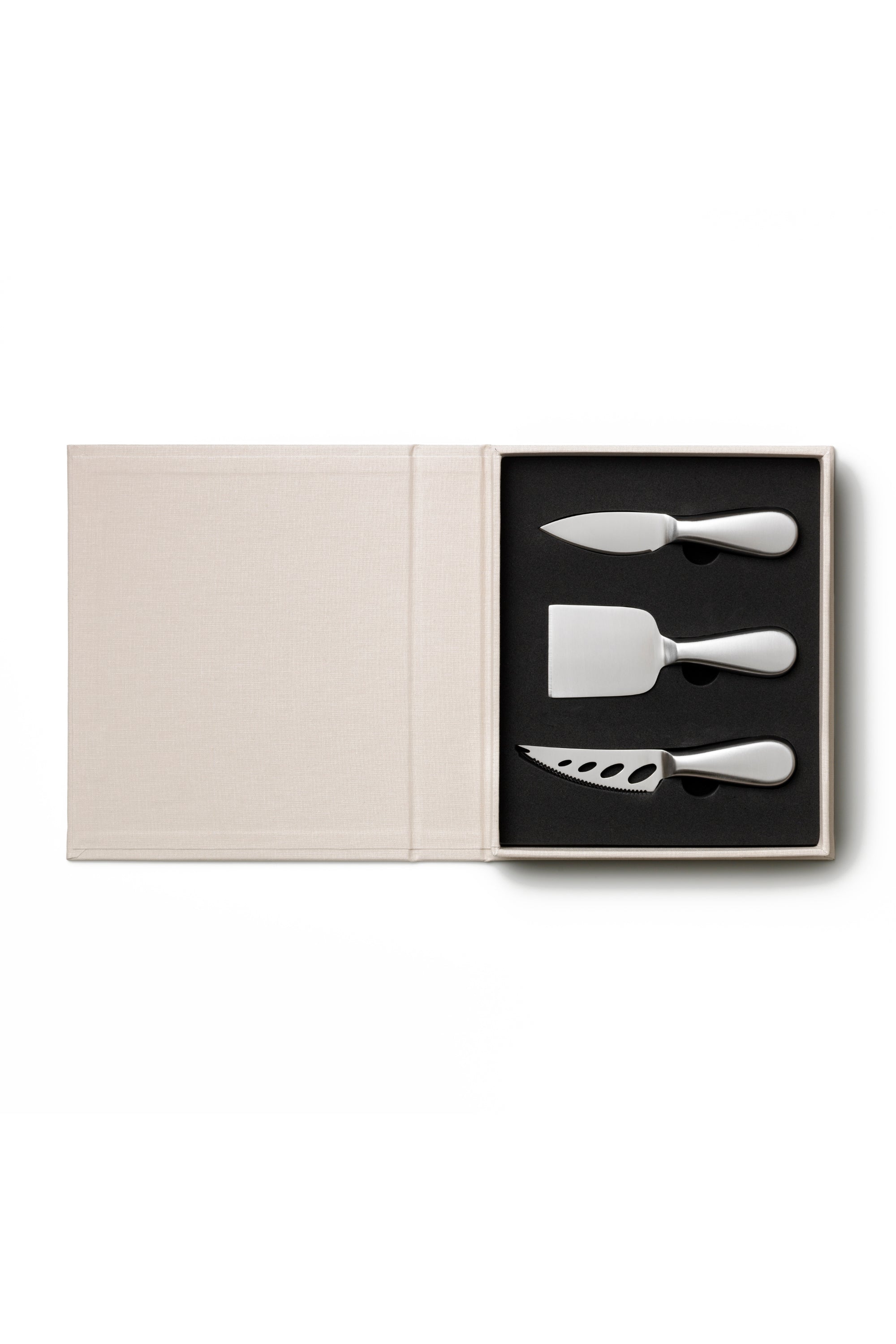 Set of three silver cheese knives in a black box on a white background